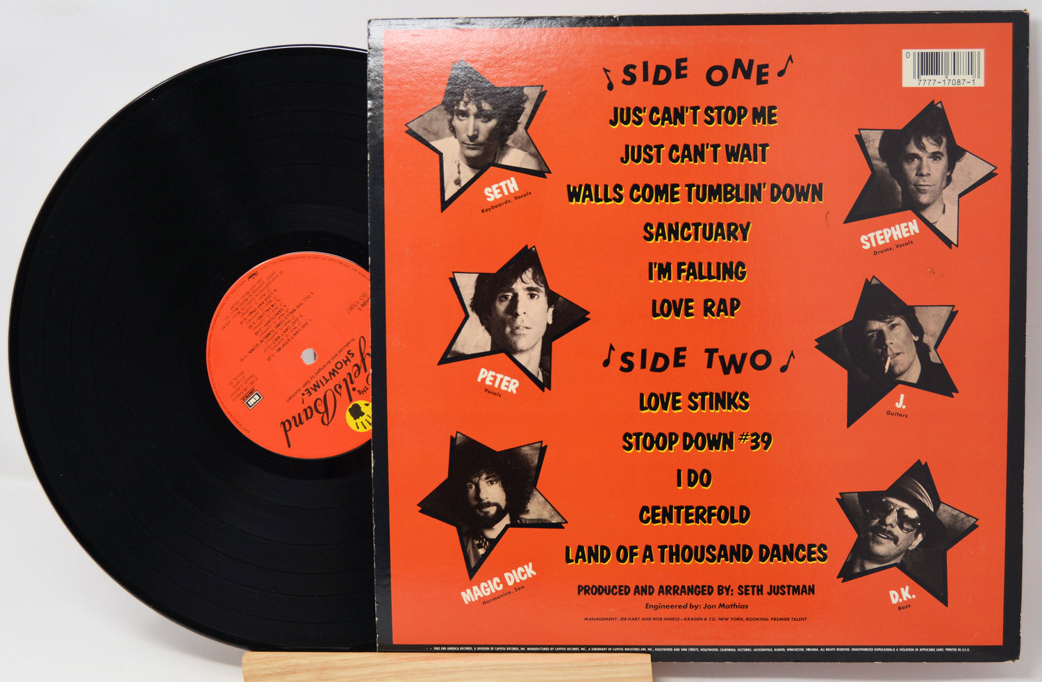 Vinyl record with orange cover featuring star-shaped cutouts of a person's face and text.