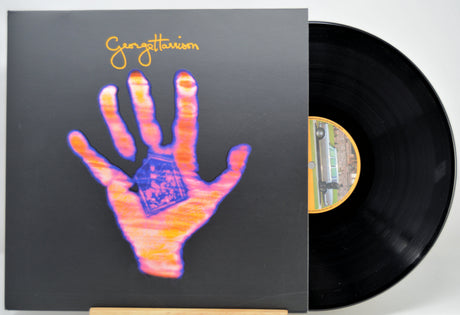 A vinyl record partially pulled from its sleeve, showing the album cover artwork with a large stylized hand in pink, orange, and blue on a dark background, and the black record disc visible behind it.