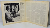 Open book with a black and white photo on the left and text on the right.