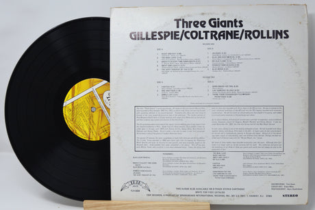 Vinyl record with cover displaying 'Three Giants' by Gillespie/Coltrane/Rollins on a white background.