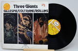Vinyl record with cover featuring illustrations of musicians and text 'Three Giants' by Gillespie/Coltrane/Rollins.