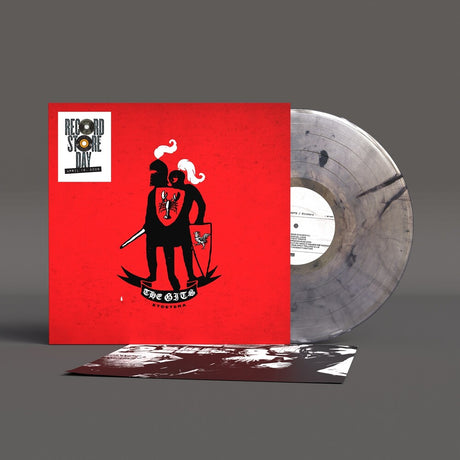Vinyl record with a red cover featuring black artwork and a clear record on a gray background