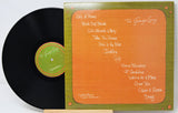 Vinyl record with orange cover featuring song titles on a white background