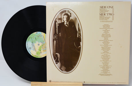 Vinyl record with cover featuring a portrait and album details on a light gray background