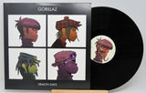 Vinyl record with Gorillaz album cover featuring four character illustrations.