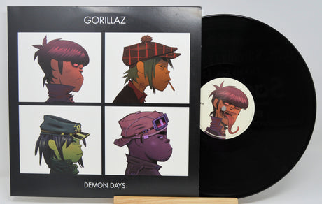 Vinyl record with Gorillaz album cover featuring four character illustrations.