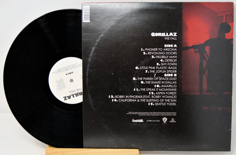 Vinyl record with cover featuring a silhouette and tracklist on a white background