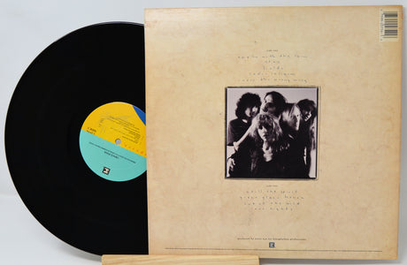 Vinyl record with a black cover featuring a band photo and a yellow label.