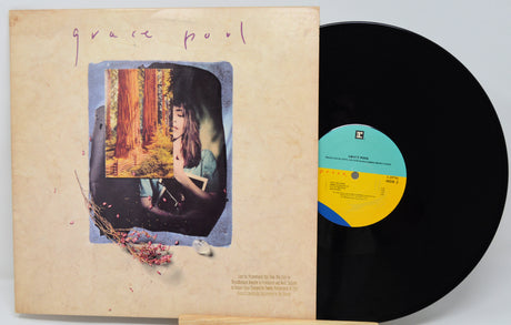 Vinyl record with cover featuring a person and nature, on a light gray background