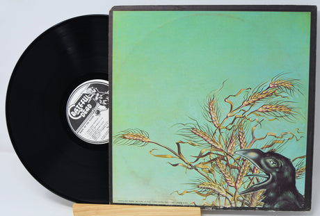 Vinyl record with a cover featuring a bird and wheat on a light blue background
