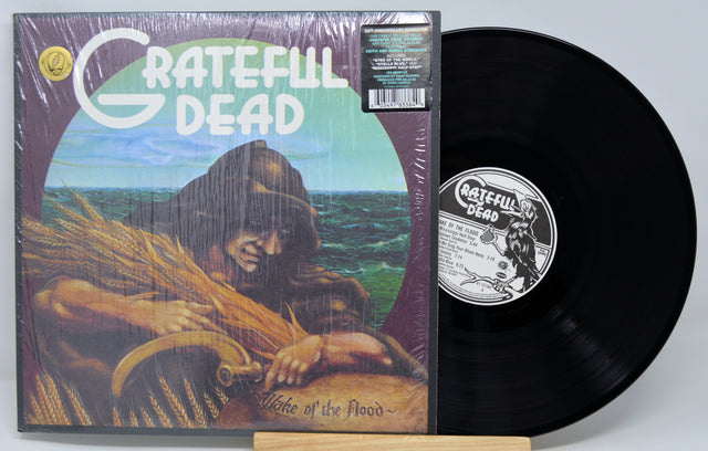 Vinyl record and cover of 'Grateful Dead' album 'Wise One of the Flood' on a light gray background