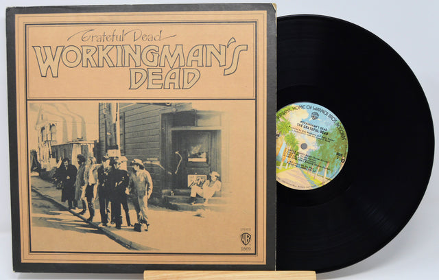 Vinyl record and cover titled 'Workingman's Dead' by Grateful Dead on a light blue background