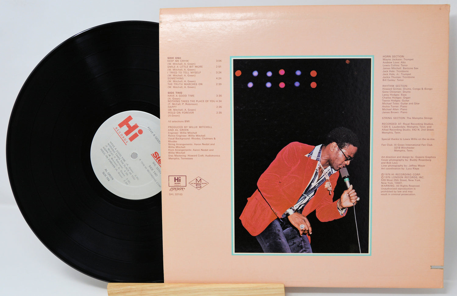 Vinyl record with cover featuring a person singing, on a light gray background