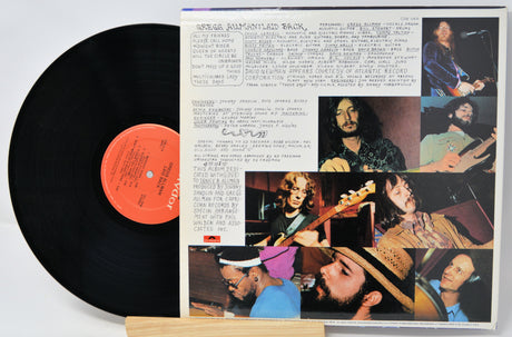 Vinyl record with a colorful cover featuring images of a band and text.