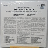 Back cover of a vinyl record sleeve for 'A Blowing Session: Johnny Griffin' on Blue Note, photographed flat against a white background with a small wooden stand visible at the bottom.