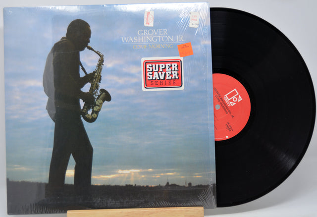 Vinyl record 'Grover Washington Jr Come Morning' with a cover featuring a silhouette of a saxophonist against a sky background.