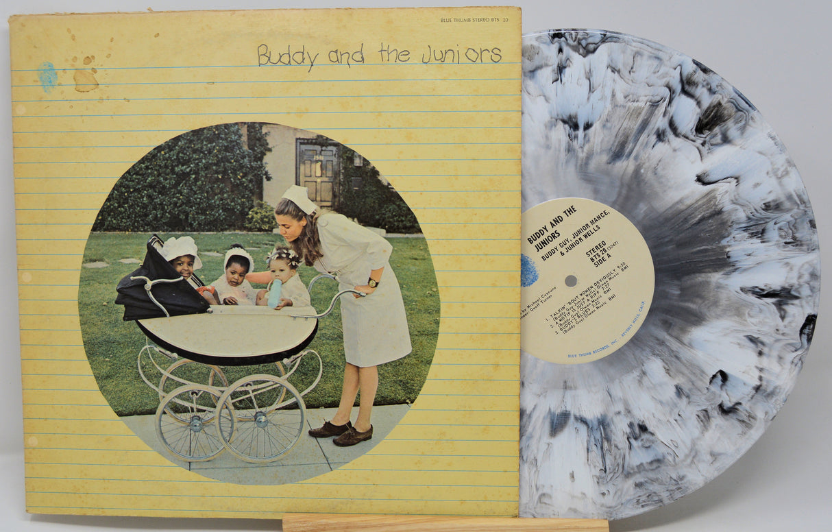 Vinyl record with cover featuring a woman and children around a baby carriage, on a yellow background.