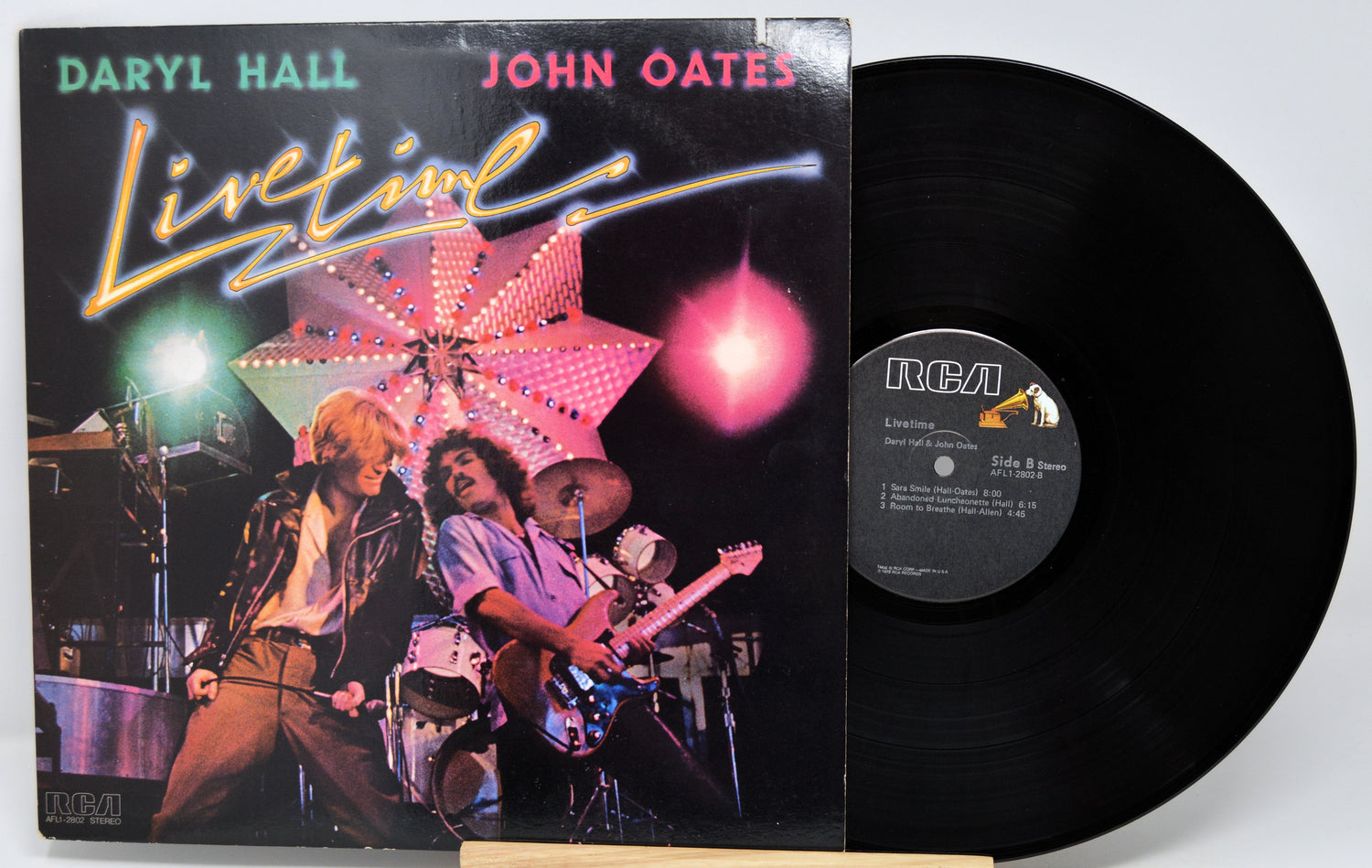Vinyl record and cover featuring Daryl Hall and John Oates with a concert scene on the cover.