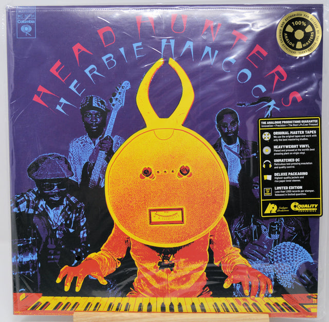 Herbie Hancock's 'Head Hunters' vinyl record album cover, sealed in its original shrink wrap. The cover art features a vibrant yellow rabbit-like character playing a piano against a purple background with the band members depicted in blue tones.