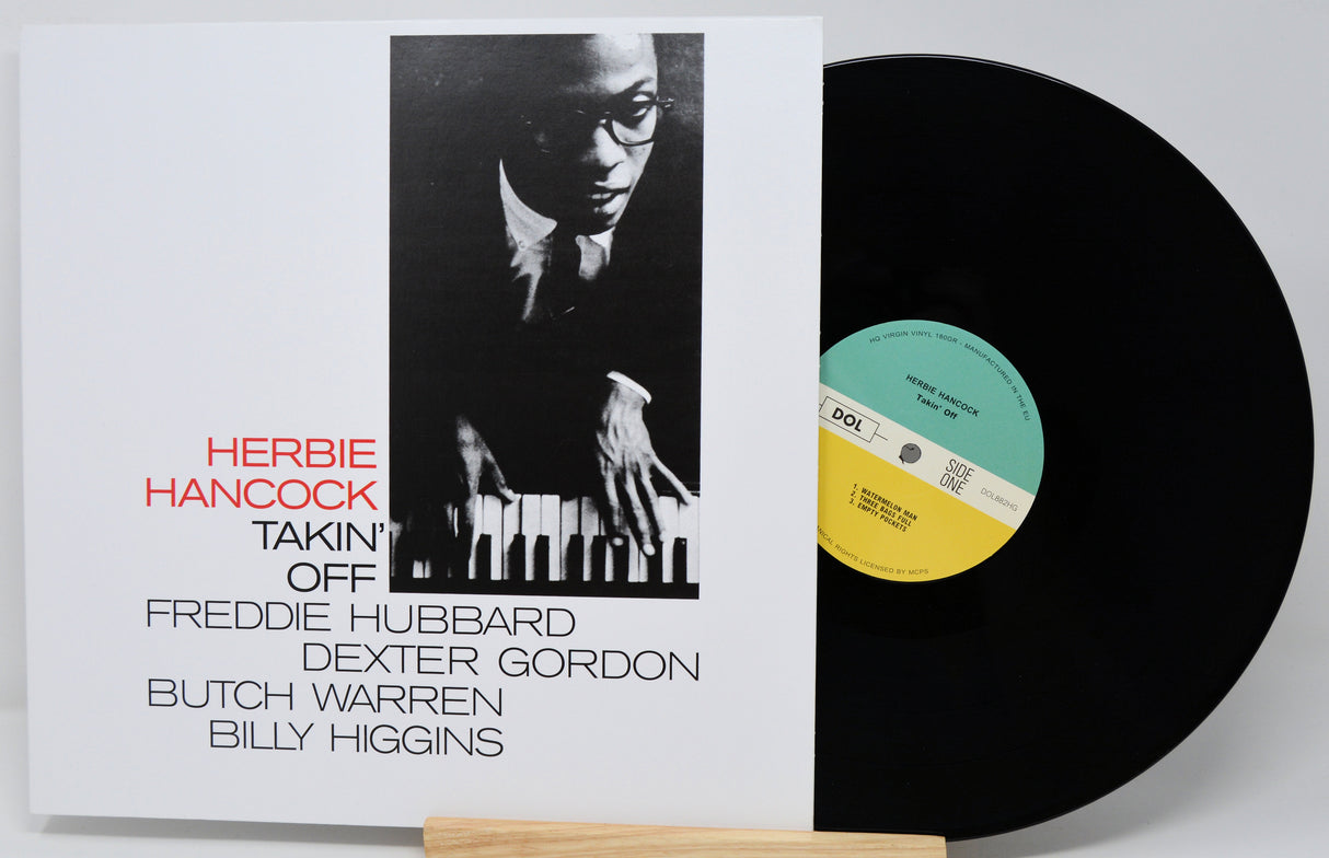 Vinyl record with cover featuring Herbie Hancock and a list of contributors on a white background