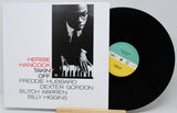 Vinyl record with cover featuring Herbie Hancock and a list of contributors on a white background