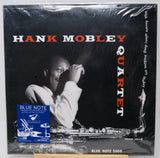 Hank Mobley Quartet vinyl record cover on a black background, sealed in plastic shrink wrap with a Blue Note sticker visible on the lower left. The cover features a black-and-white photo of Hank Mobley with red and white text reading 'HANK MOBLEY QUARTET'.