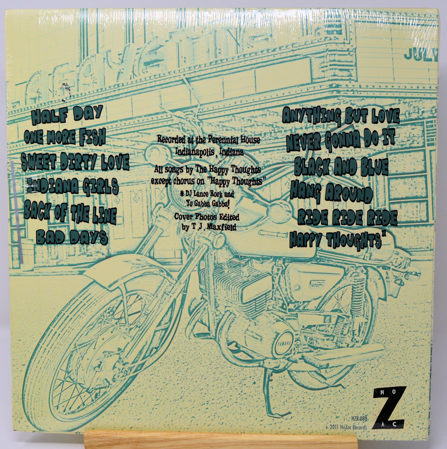 Album cover with motorcycle illustration and text on a yellowed paper background