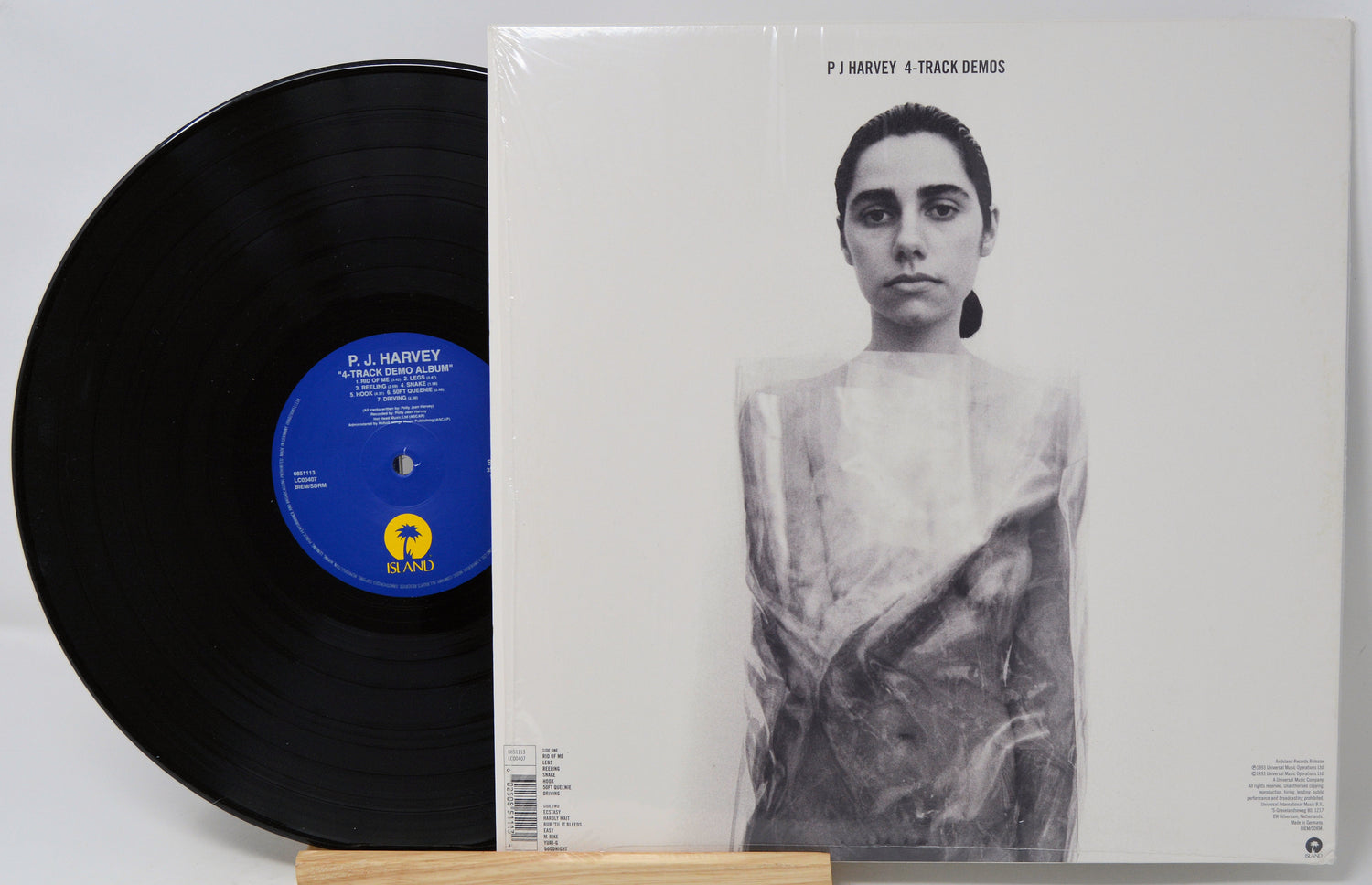 Vinyl record and its cover featuring a black and white portrait on a light gray background