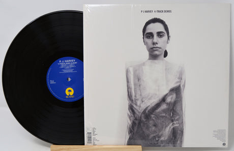 Vinyl record and its cover featuring a black and white portrait on a light gray background