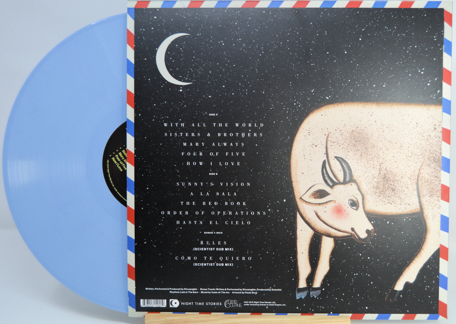 Back cover of Khruangbin's Hasta El Cielo LP with cosmic artwork, song list, crescent moon, and illustrated cow