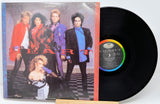 Vinyl record with cover featuring a band on a checkered floor background