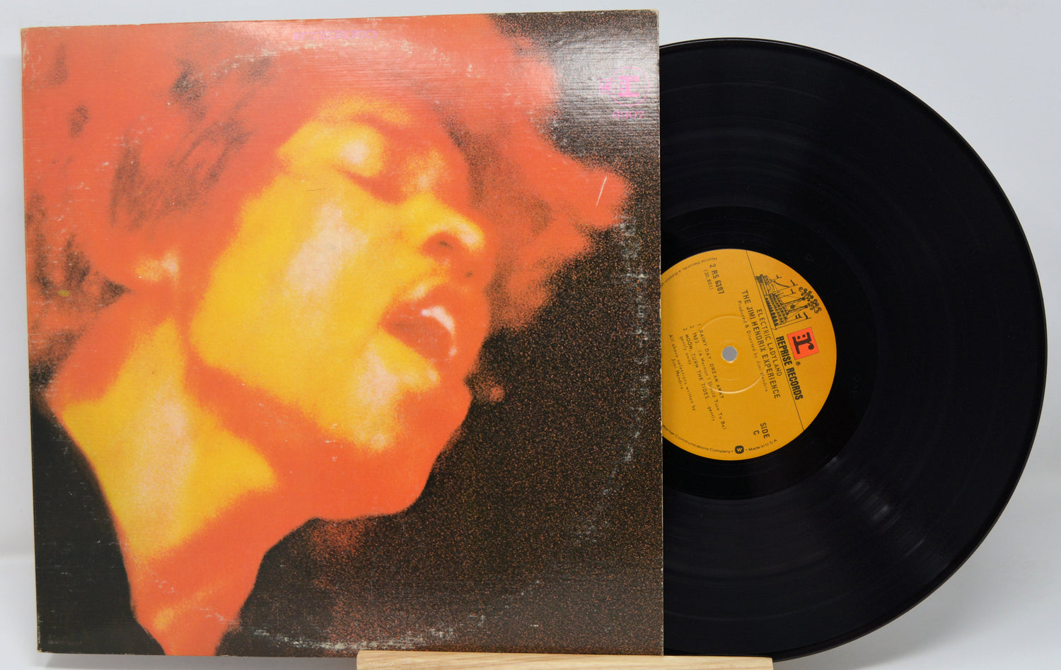 Vinyl record with a colorful cover featuring a face and a yellow label.