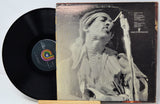 Vinyl record with a black cover featuring a person singing into a microphone.