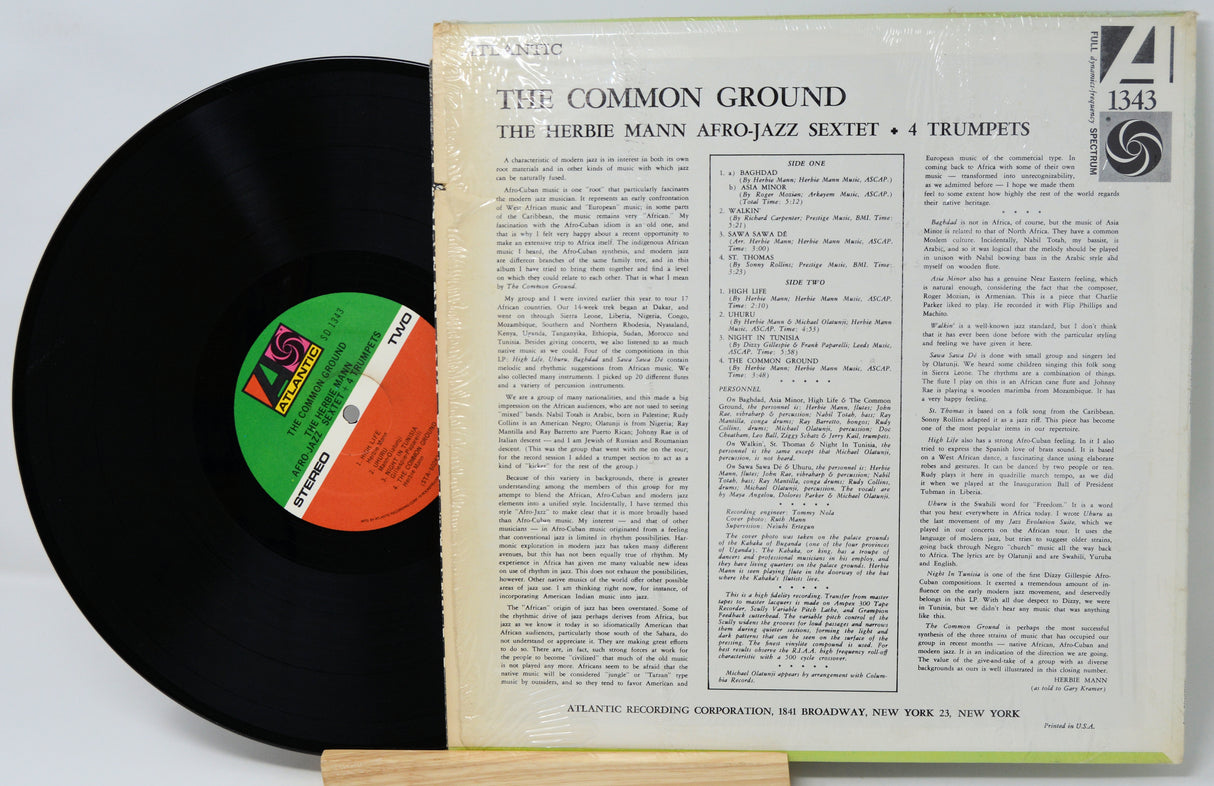 Vinyl record with cover displaying text and a logo on a white background