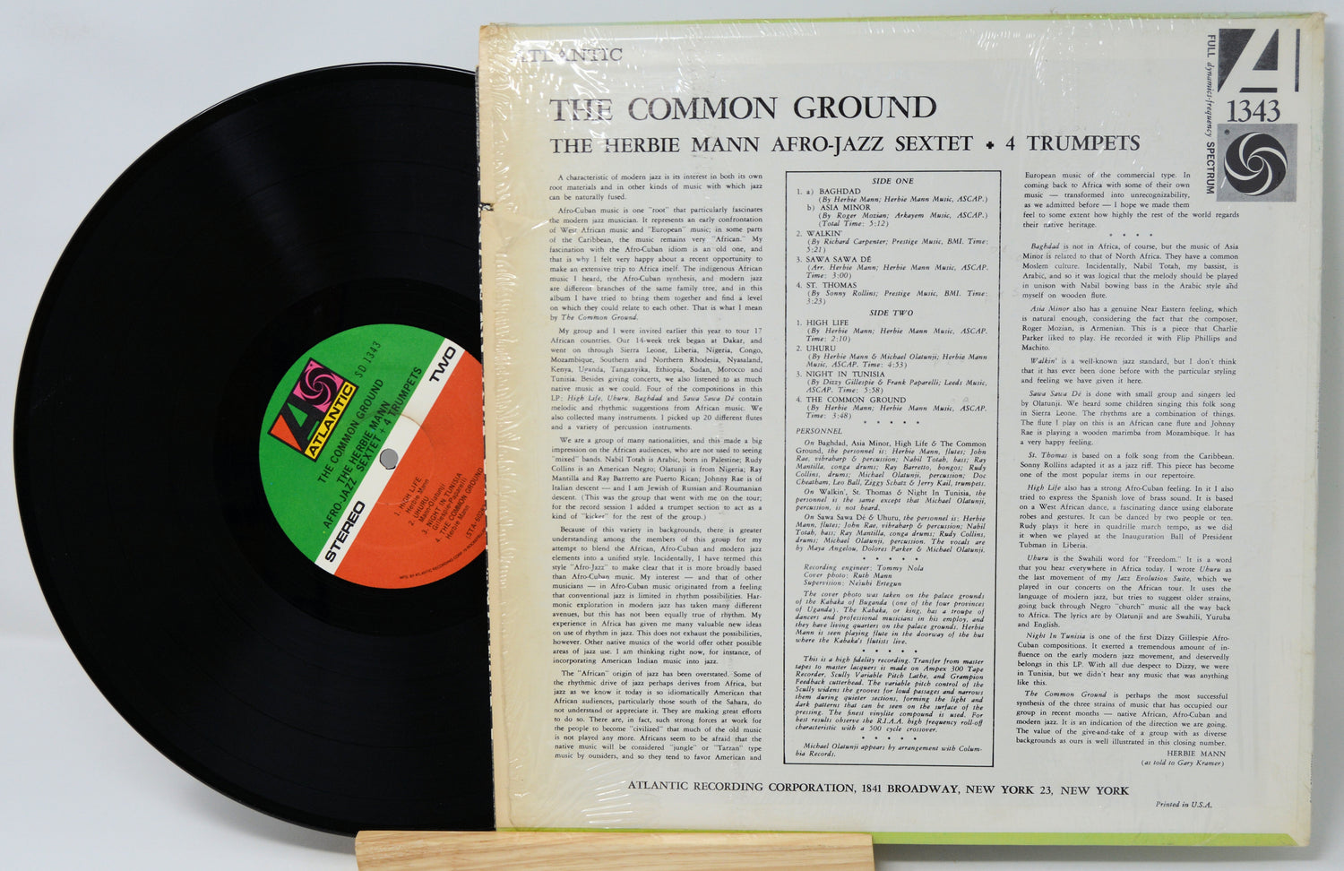 Vinyl record with cover displaying text and a logo on a white background