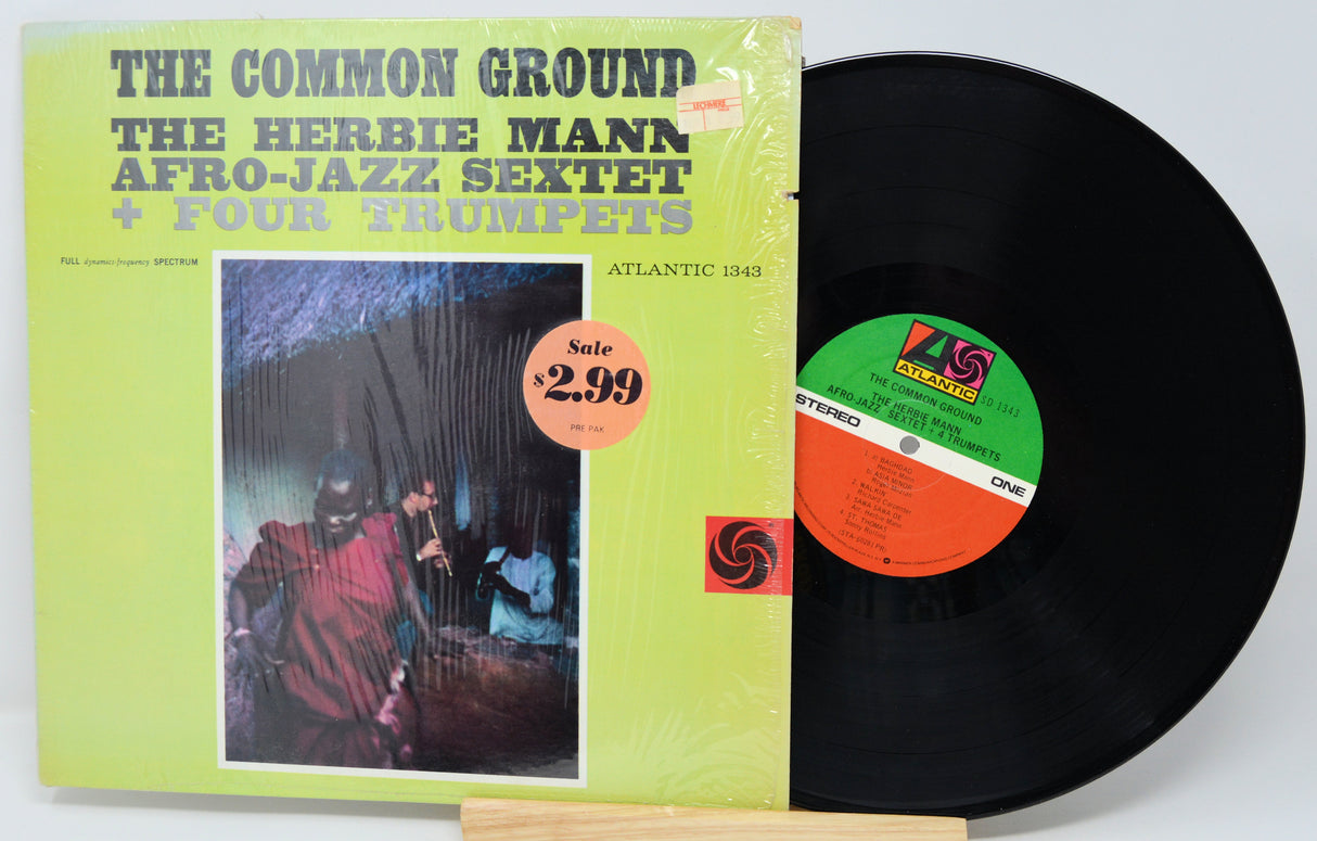 Vinyl record with green cover featuring text and a price tag, on a white background