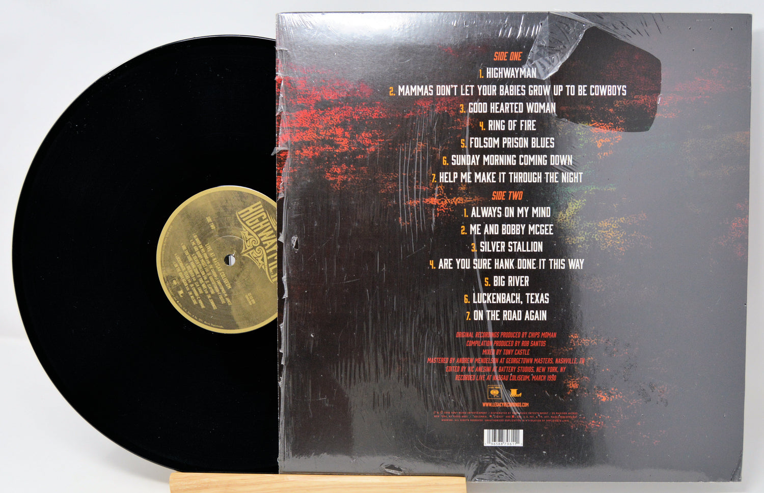 Vinyl record with its cover displaying tracklist on a white background