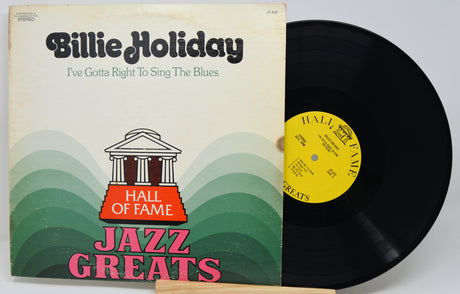 Billie Holiday 'Jazz Greats' vinyl record LP with the album cover on the left and the black record partially pulled out on the right, set against a plain light background.