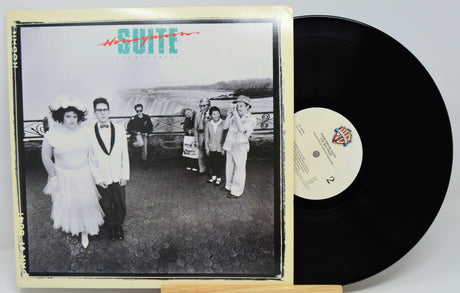 A vinyl record and its album cover for 'Suite: The Musical' by The Who, displayed on a small wooden stand against a light gray background.
