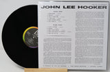 A vinyl record partially pulled from its sleeve, showing the black record on the left and the printed inner sleeve track listing on the right. The sleeve reads 'JOHN LEE HOOKER' and 'VIE JAY LP-CRS0054'.