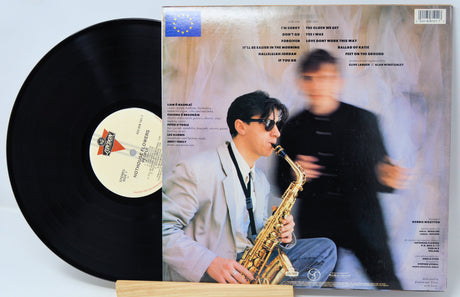 Vinyl record with a cover featuring a person playing saxophone on a light gray background