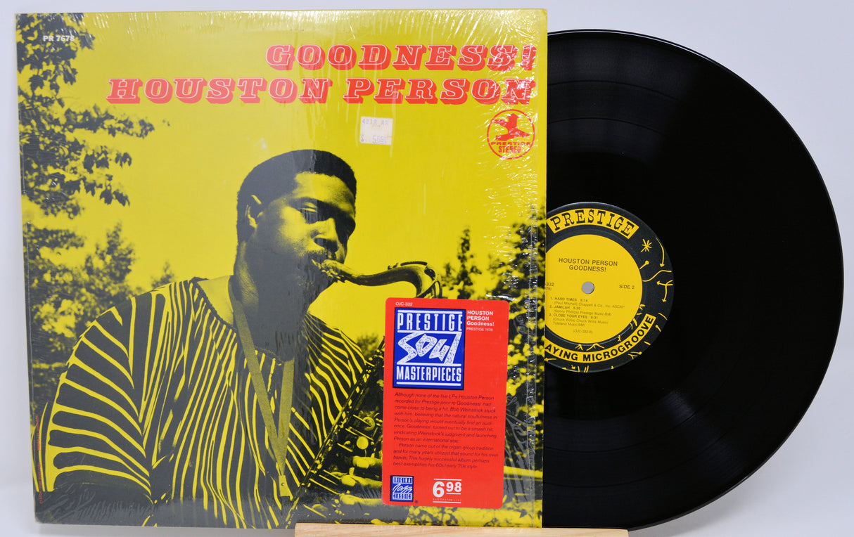 Vinyl record with a yellow and black cover featuring a person playing a saxophone, on a white background.