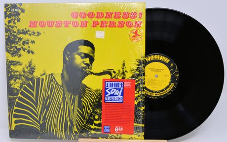Vinyl record with a yellow and black cover featuring a person playing a saxophone, on a white background.