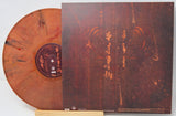Vinyl record with orange-brown disc and matching cover on a white background