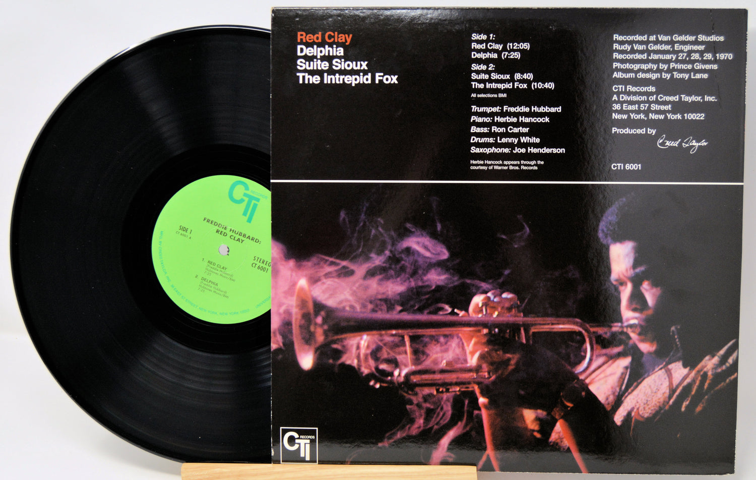 Vinyl record and its cover featuring a person with a rifle and smoke, with 'Red Clay' and 'Delphiia Suite Sioux' text.