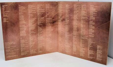 Folded bronze plaque with engraved text on a white background