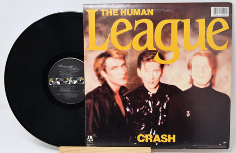 Vinyl record and cover of 'The Human League' album 'Crash' on a white background