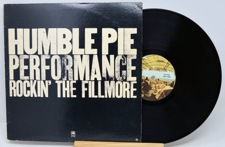 Humble Pie Performance 'Rockin' The Fillmore' vinyl record with the black album cover and part of the black record visible, displayed on a small wooden stand against a light gray background.