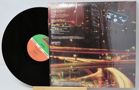 Vinyl record with cover featuring a cityscape at night.