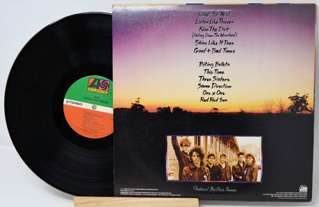 Vinyl record with cover featuring a sunset landscape and band photo.